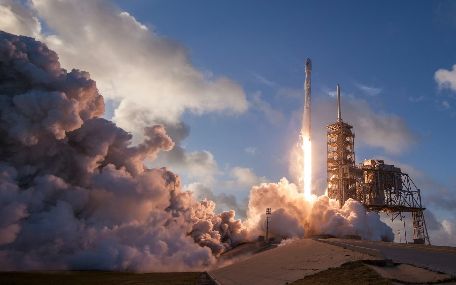 A rocket lifting off through billowing clouds of exhaust