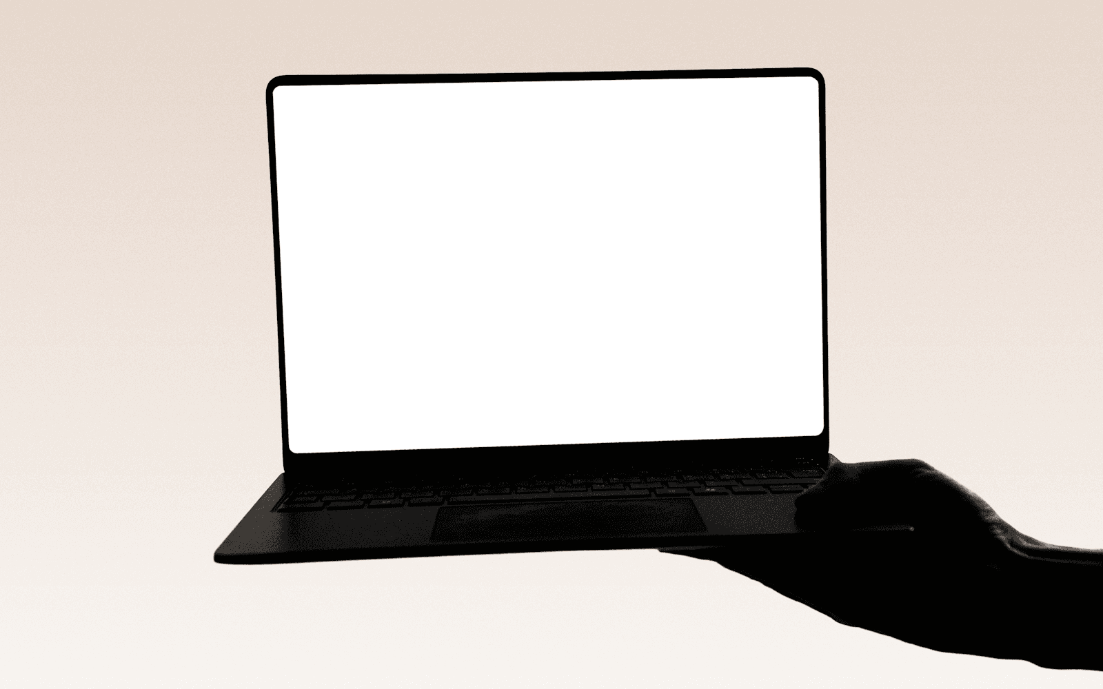 An open laptop showing a blank white screen on a plain desk